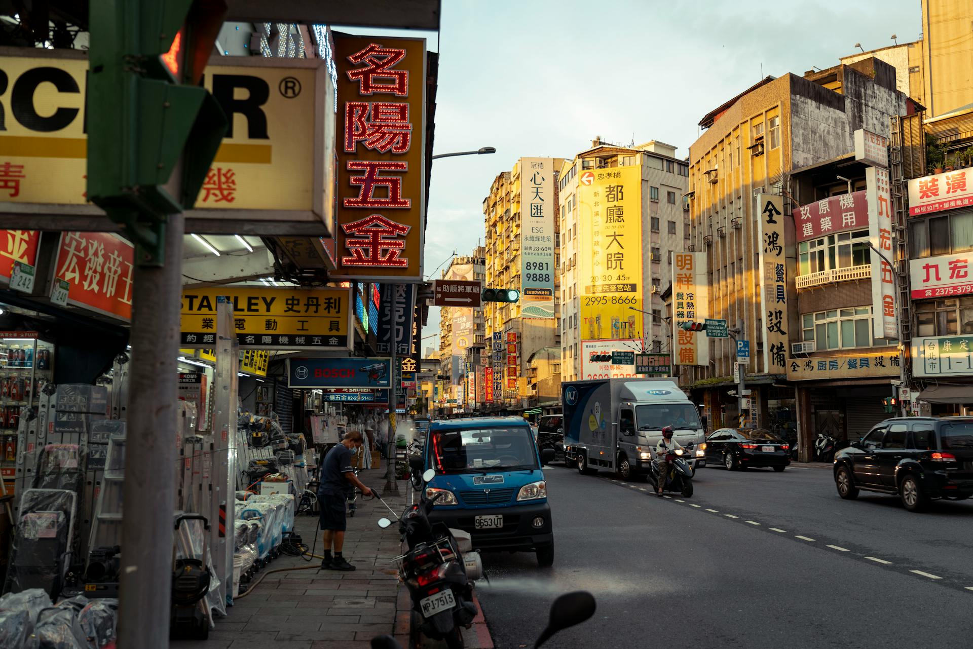 Vibrant street scene in a busy East Asian city with signs and traffic.