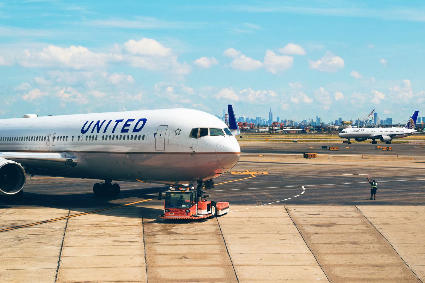 An aircraft on the tarmac at Newark Liberty airport with the New York skyline behind
