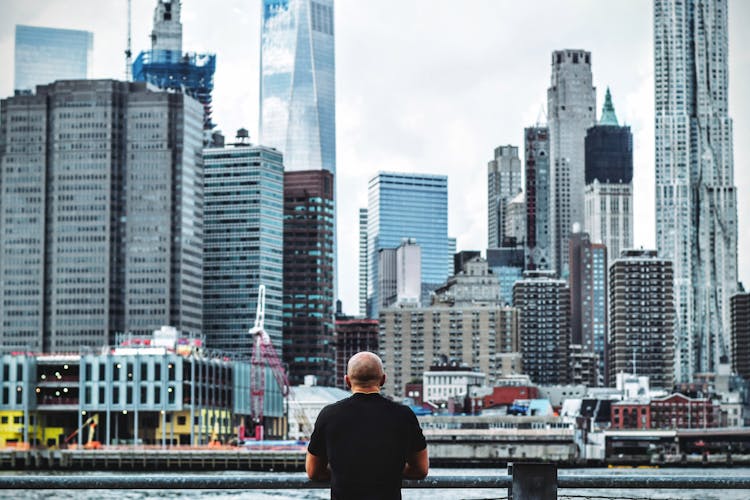 Man In Black T Shirt In Front On City Skyline During Daytime