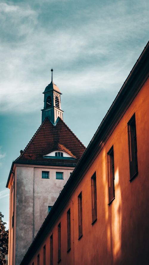 Free A captivating view of a historic Gothic building with a tower in Berlin, Germany, under a dramatic sky. Stock Photo