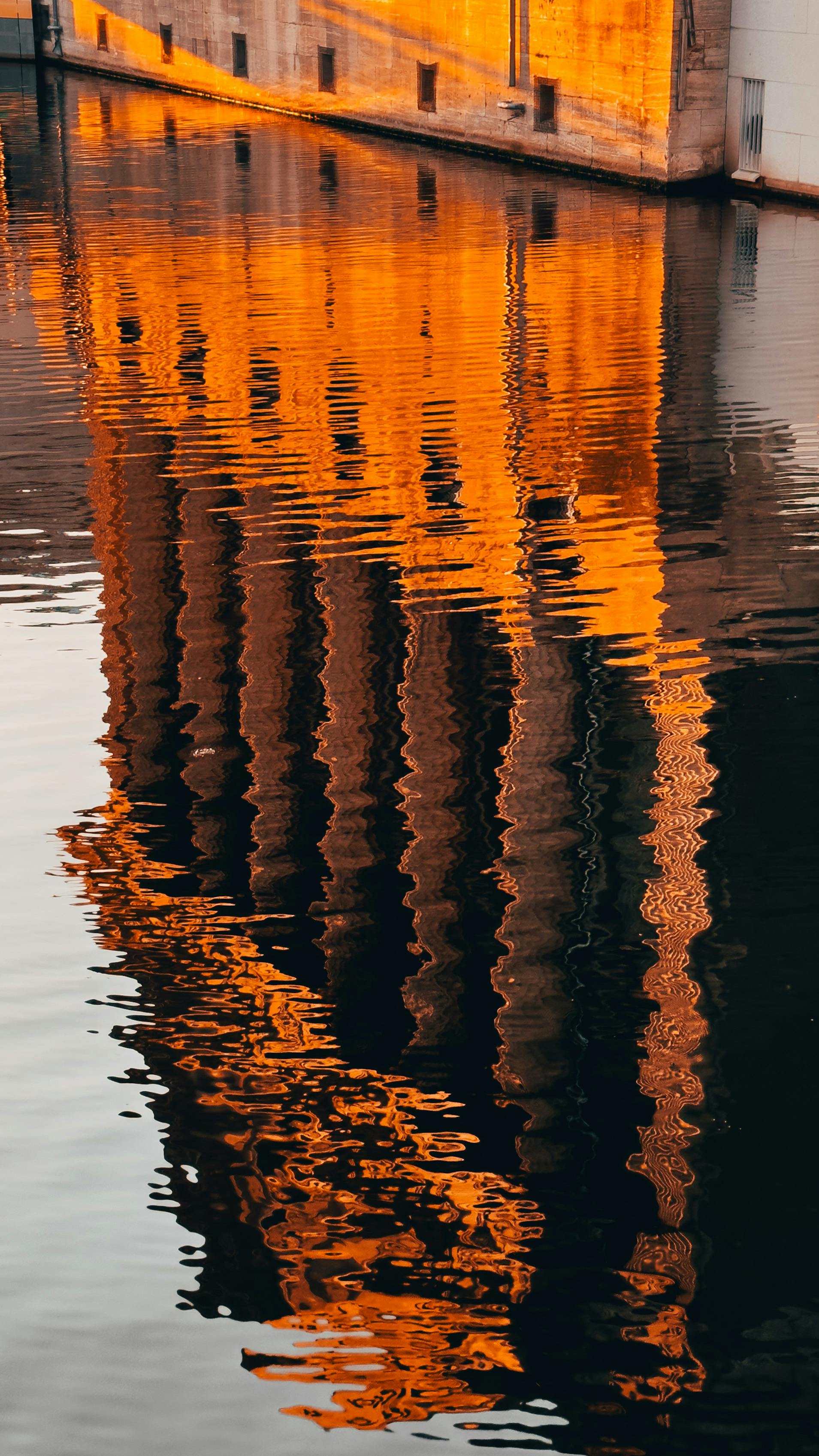 Vibrant reflection of a Berlin neoclassical building on the river at sunset.