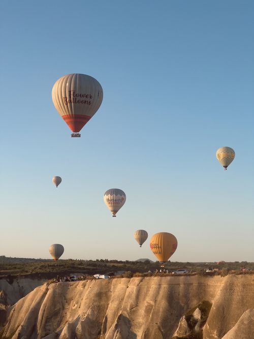 Free Hot air balloons float above Cappadocia's unique landscape at sunrise, a top travel destination in Turkey. Stock Photo