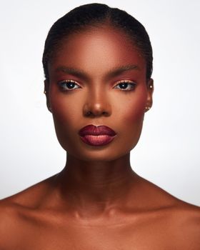 A striking studio portrait of a woman with bold lipstick and makeup, showcasing elegance and beauty.