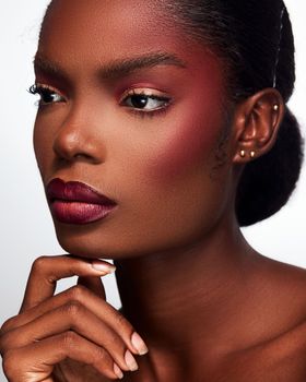 Close-up portrait of a woman with striking makeup and elegant pose, highlighting beauty and confidence.