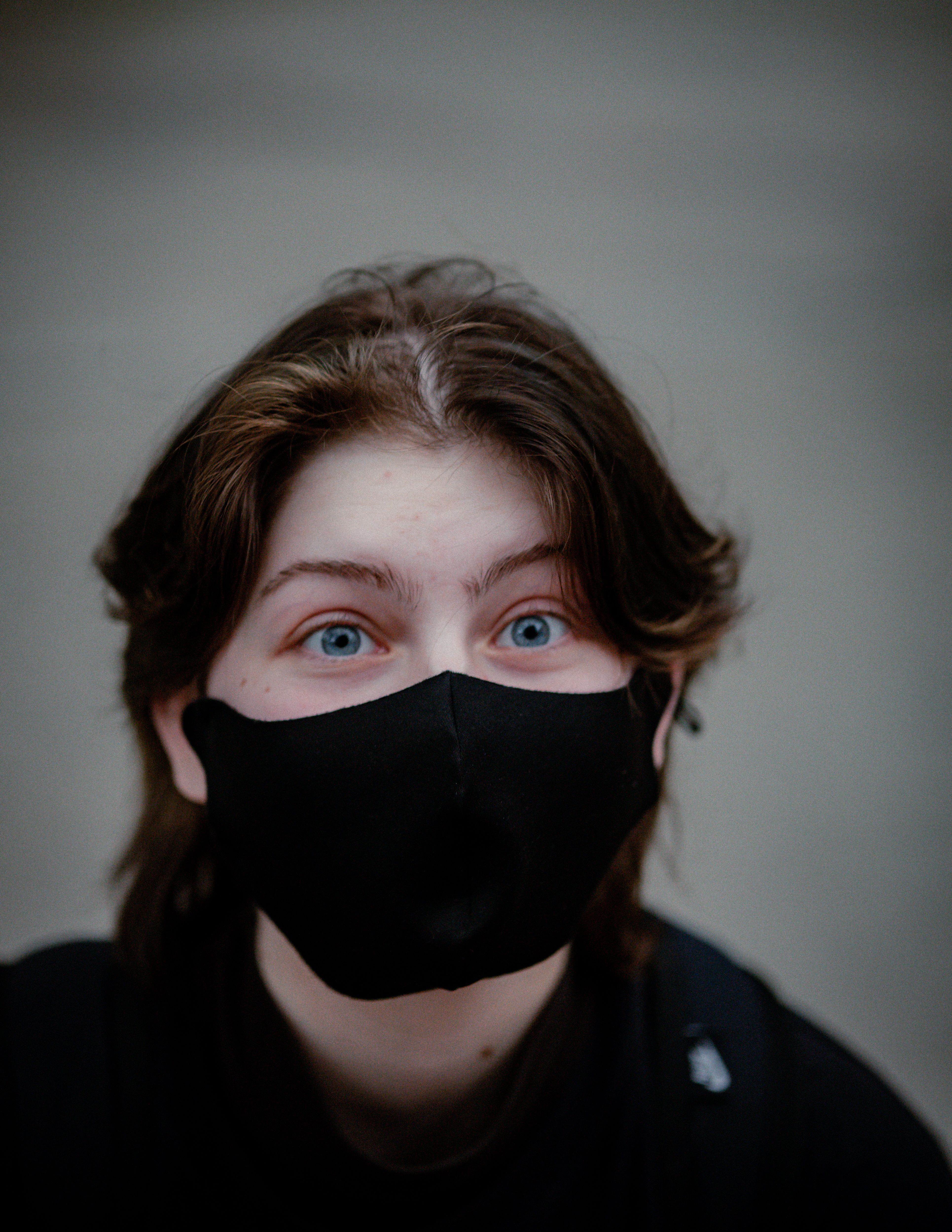 Portrait of a Young Person Wearing a Black Face Mask · Free Stock Photo