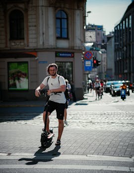 A young man navigates city streets on an electric scooter, showcasing modern urban commuting.