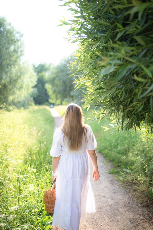 Blonde Woman in White Dress Walking on Footpath