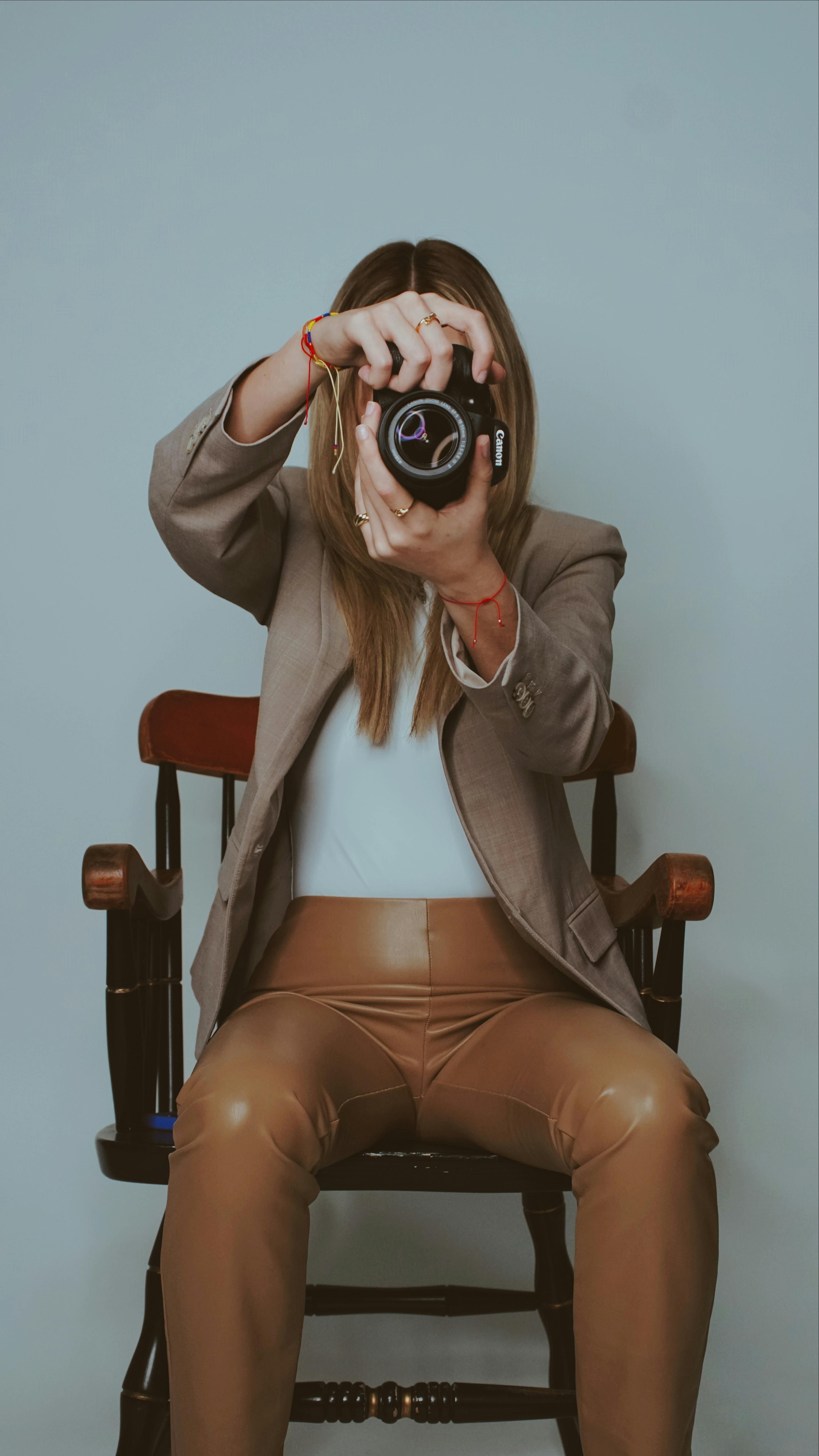 A stylish female photographer in brown attire capturing a shot in a Miami studio.