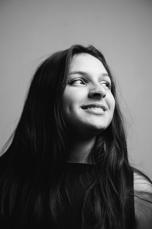 Free Striking black and white portrait of a woman with long hair and a captivating smile. Stock Photo