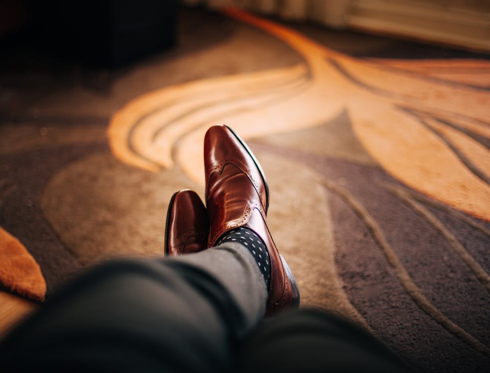 Неглубокая фотография человека в коричневых кожаных классических туфлях