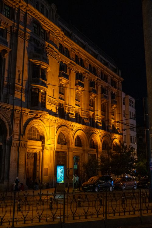 Free Elegant night view of a historic building in Istanbul, showcasing its illuminated facade and vibrant urban life. Stock Photo