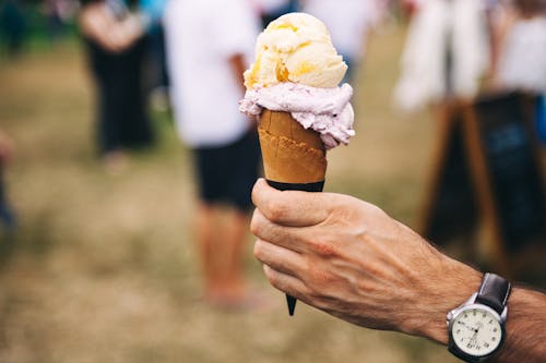 無料 黄色と紫のアイスクリームを持っている人 写真素材