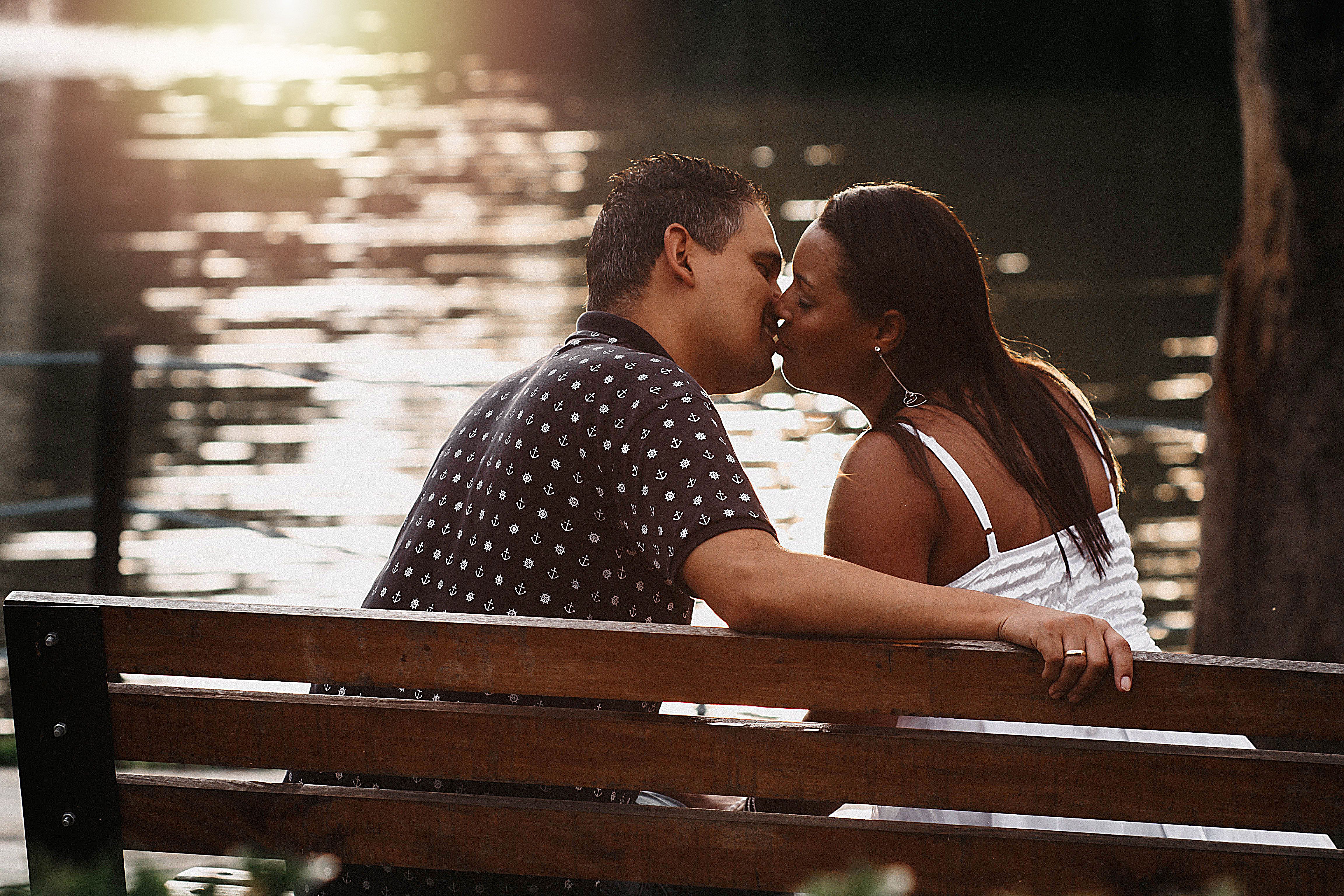Kissing Couple Sitting on Bench · Free Stock Photo