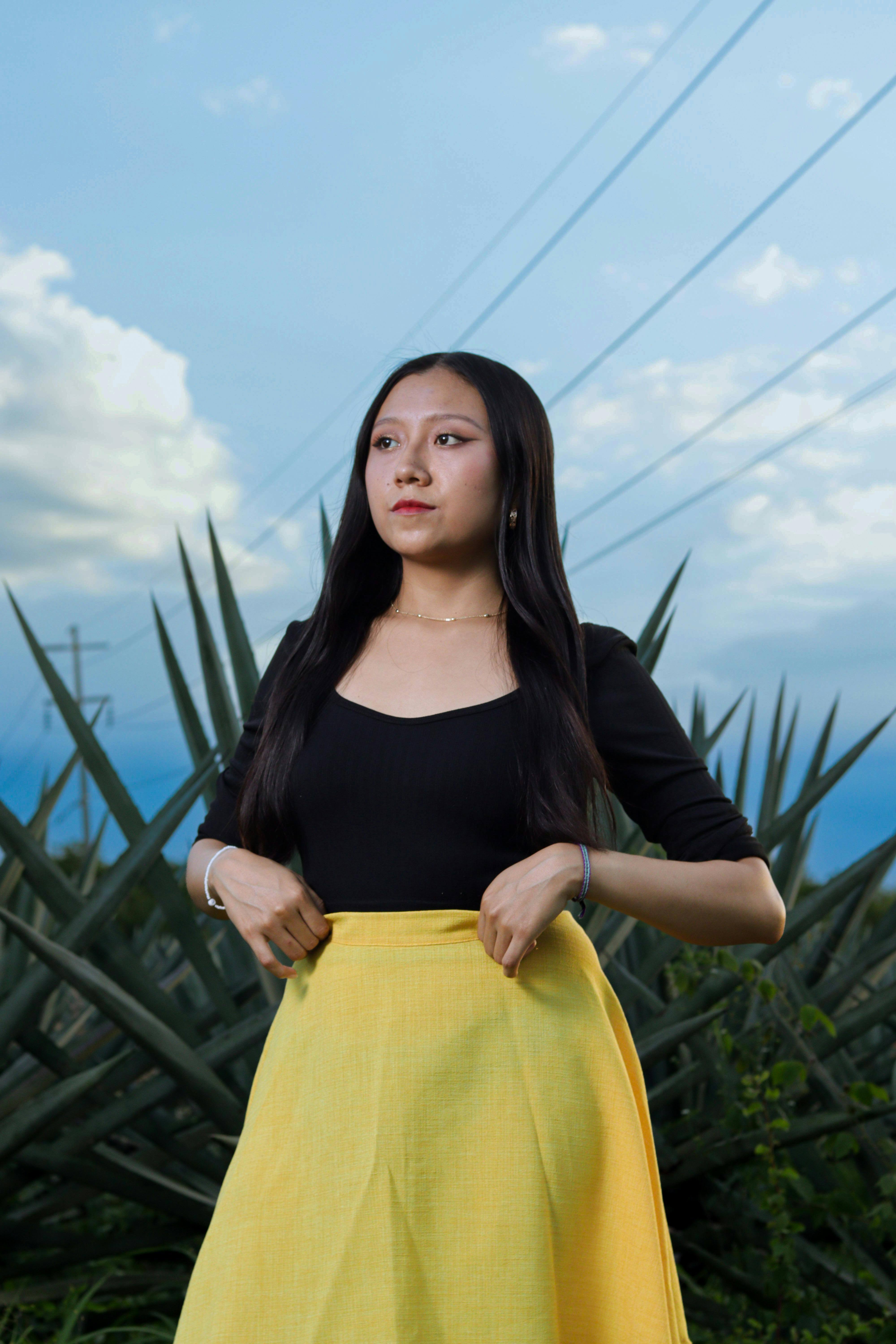 Young Woman in a Black Blouse and Yellow Skirt Free Stock Photo