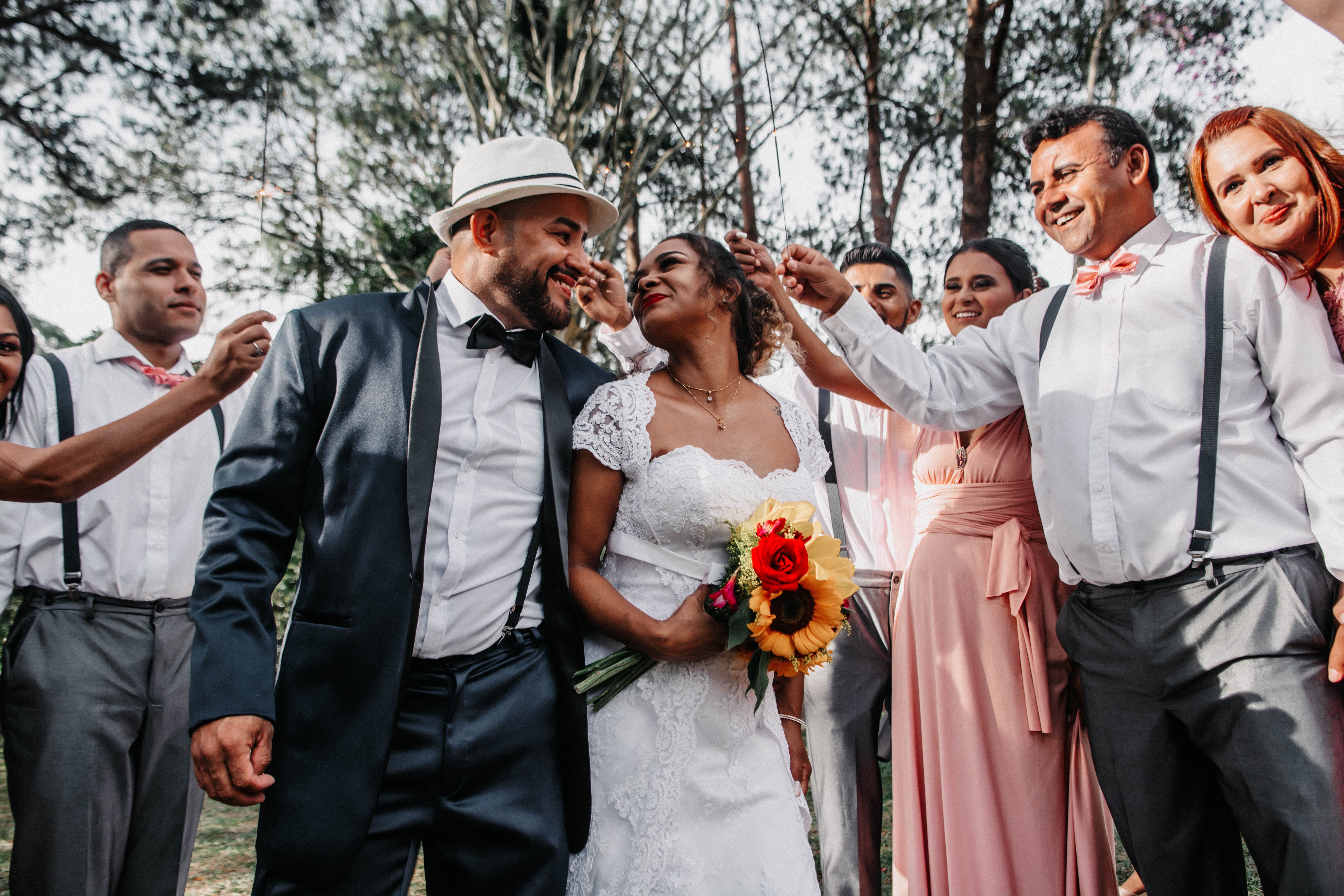 groom laughing and wearing a custom sash or hat with groomsmen at a bar, candid and celebratory