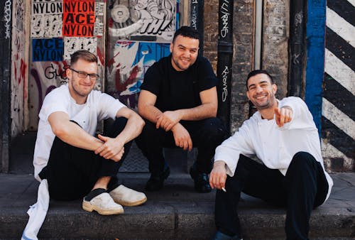 Free Three Men Sitting on Street Curb Stock Photo