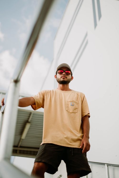 Free Fashionable man with sunglasses poses in an urban setting wearing a casual outfit. Stock Photo