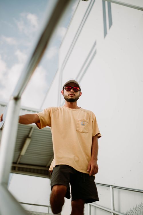 Free Stylish young man in casual attire posing confidently outdoors. Stock Photo