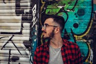 Man Wearing Black Framed Eyeglasses Standing Beside Blue and Black Wall