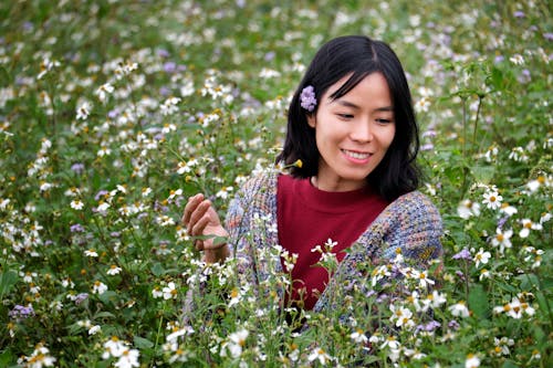 A Woman Standing between Flowers on a Field 