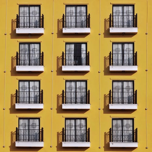 Free Facade of a Yellow Apartment Building with Balconies  Stock Photo