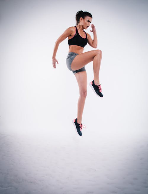 Woman Jumping on White Sand