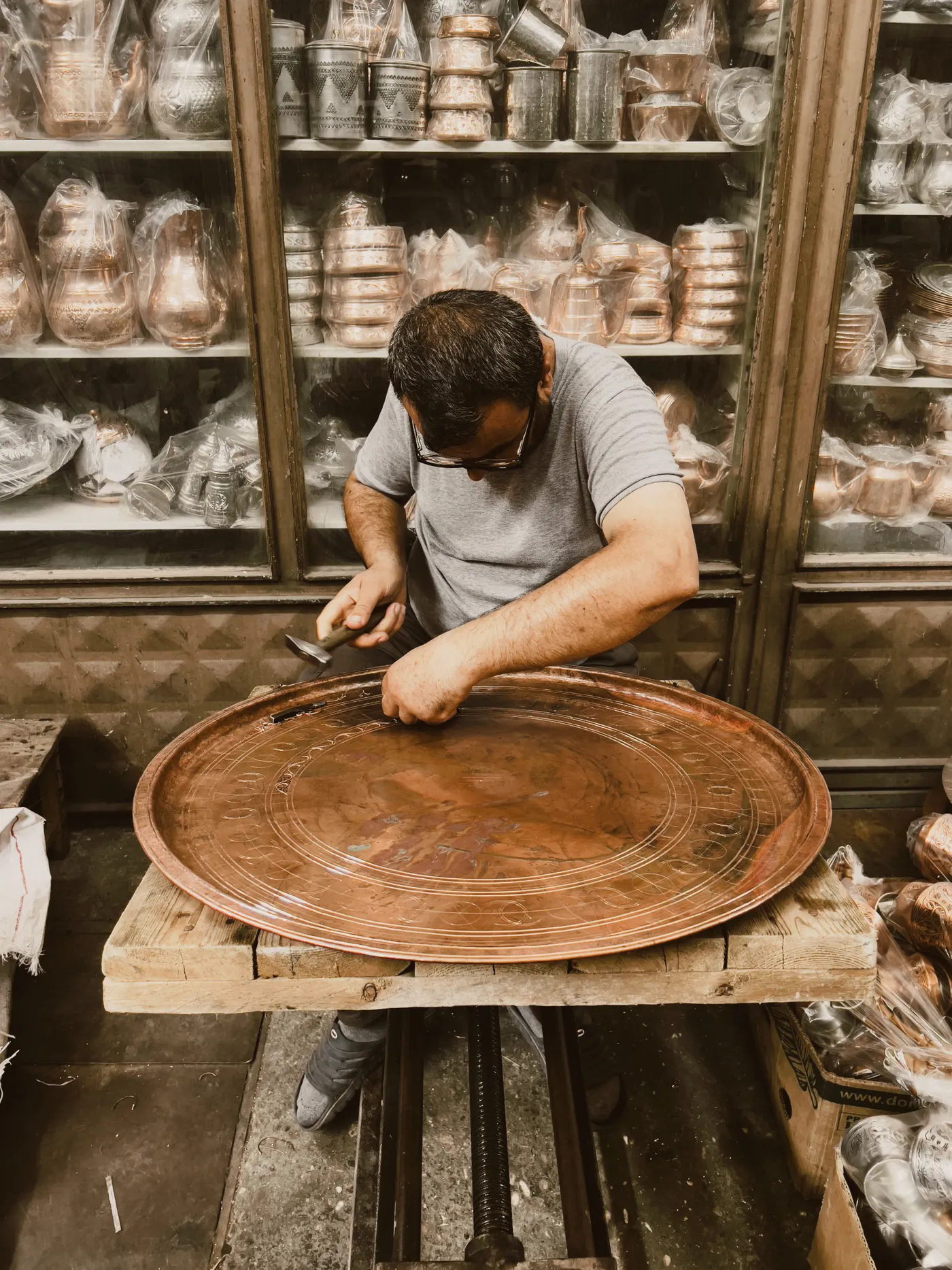 Copper artisan working in a detailed handcraft workshop