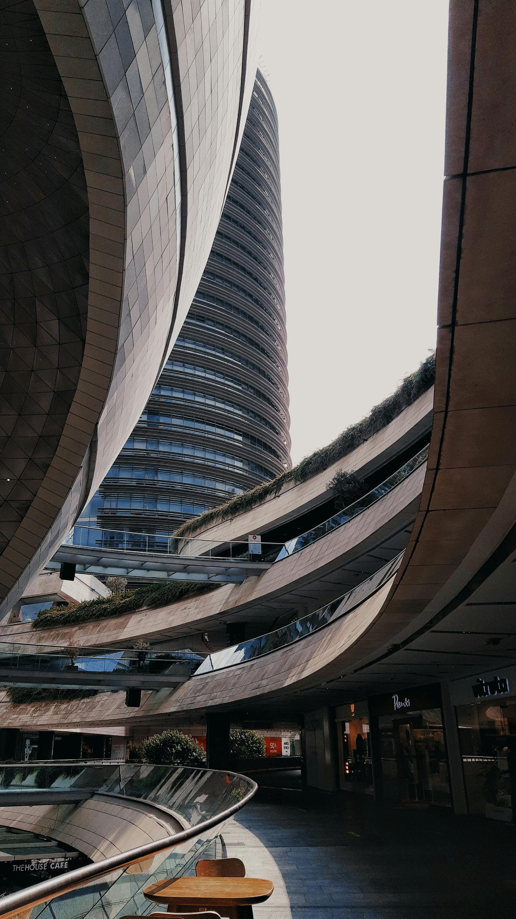 Expansive view of a modern shopping mall in Istanbul with curved glass and concrete facades.