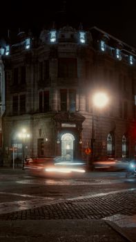 A historic building in Puebla illuminated at night with blurred car lights in motion.