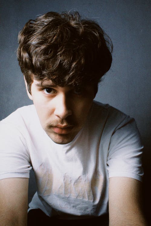 Studio Shot of a Young Man with Mustache Wearing a White T-shirt