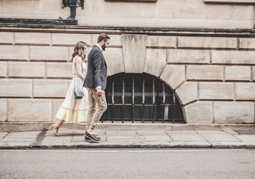免费 黑色礼服外套的男人与女人穿着白色无袖连衣裙一起散步 素材图片