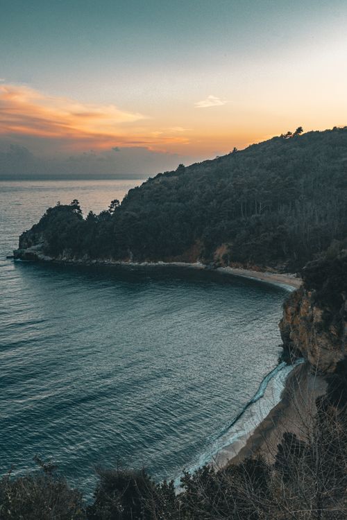 Free Captivating sunset over Budva, Montenegro's coastline with cliffs and lush forests. Stock Photo