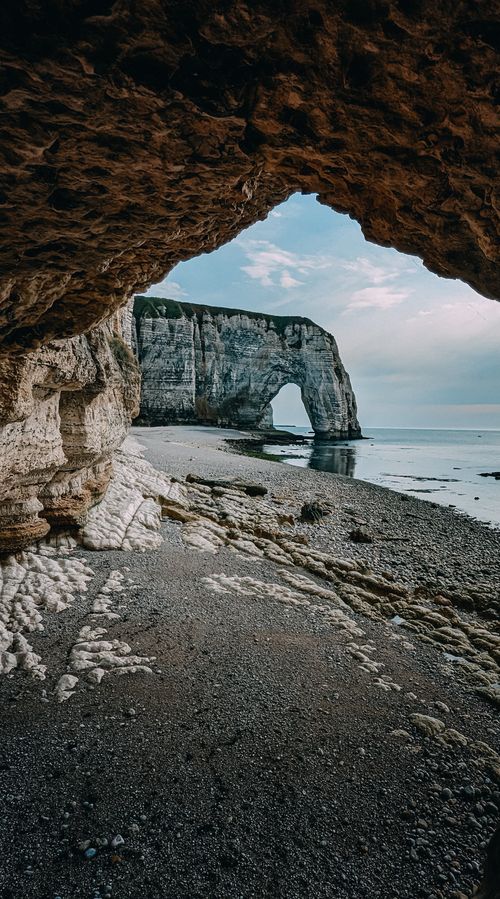 Arch Behind Woman in Bikini Sitting on Beach with Natural Arch behind · Free Stock ...