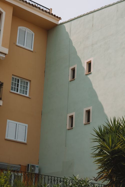 Free A vibrant urban building corner in Valencia with contrasting walls and windows. Stock Photo