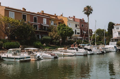 Motorboats Moored near Houses in Town on Shore