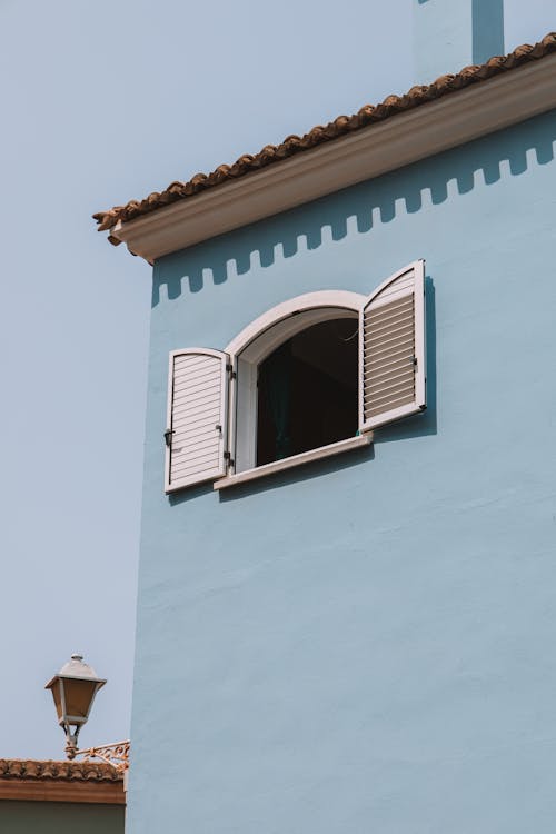 Window with Shutters on Blue Wall