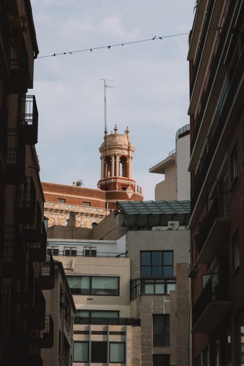 Free View of a historic bell tower amid urban buildings in Valencia, Spain. Stock Photo