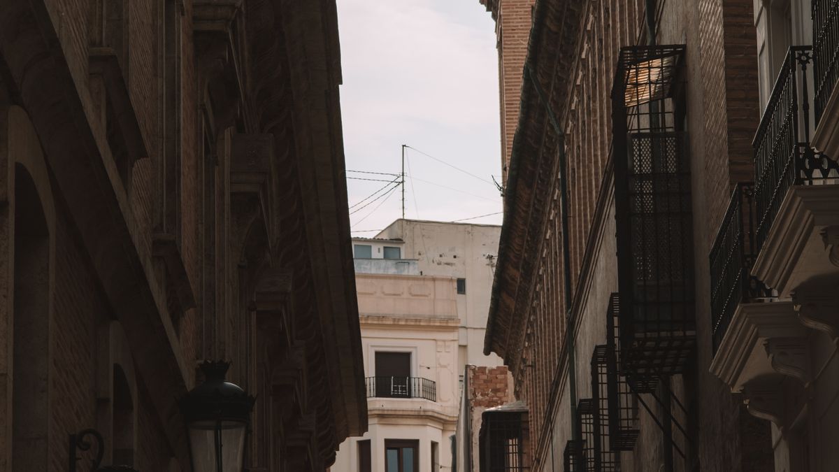 A street in Valencia's old town with historic architecture and cafe tables