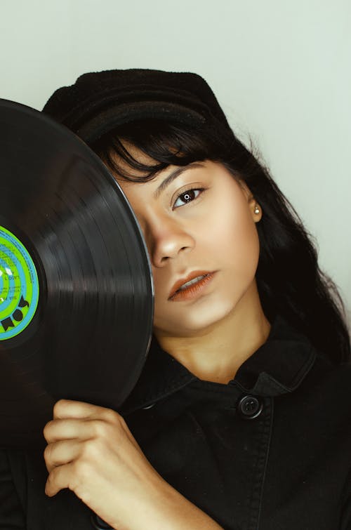 Portrait of Woman Holding Vinyl Record to her Face