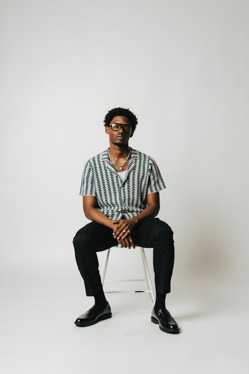 Man in Shirt Sitting on Chair in Studio