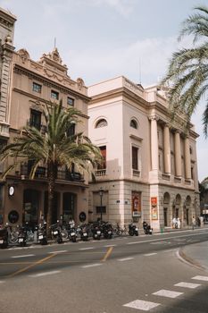 Street view of historic buildings and motor scooters in Valencia, Spain on a sunny day.