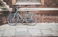 一辆古色古香的自行车停在质朴的砖墙上，车篮营造出迷人而怀旧的场景