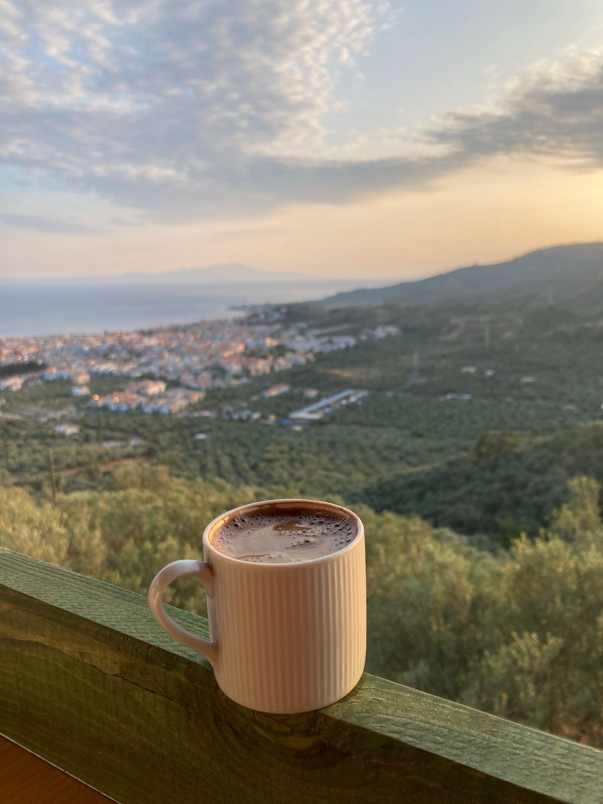 Cup of coffee resting on a balcony railing table