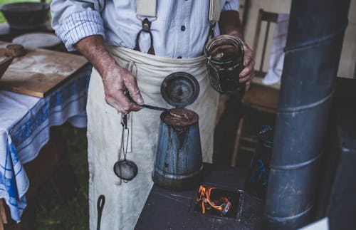 Man Holding Jar While Scooping on Kettle