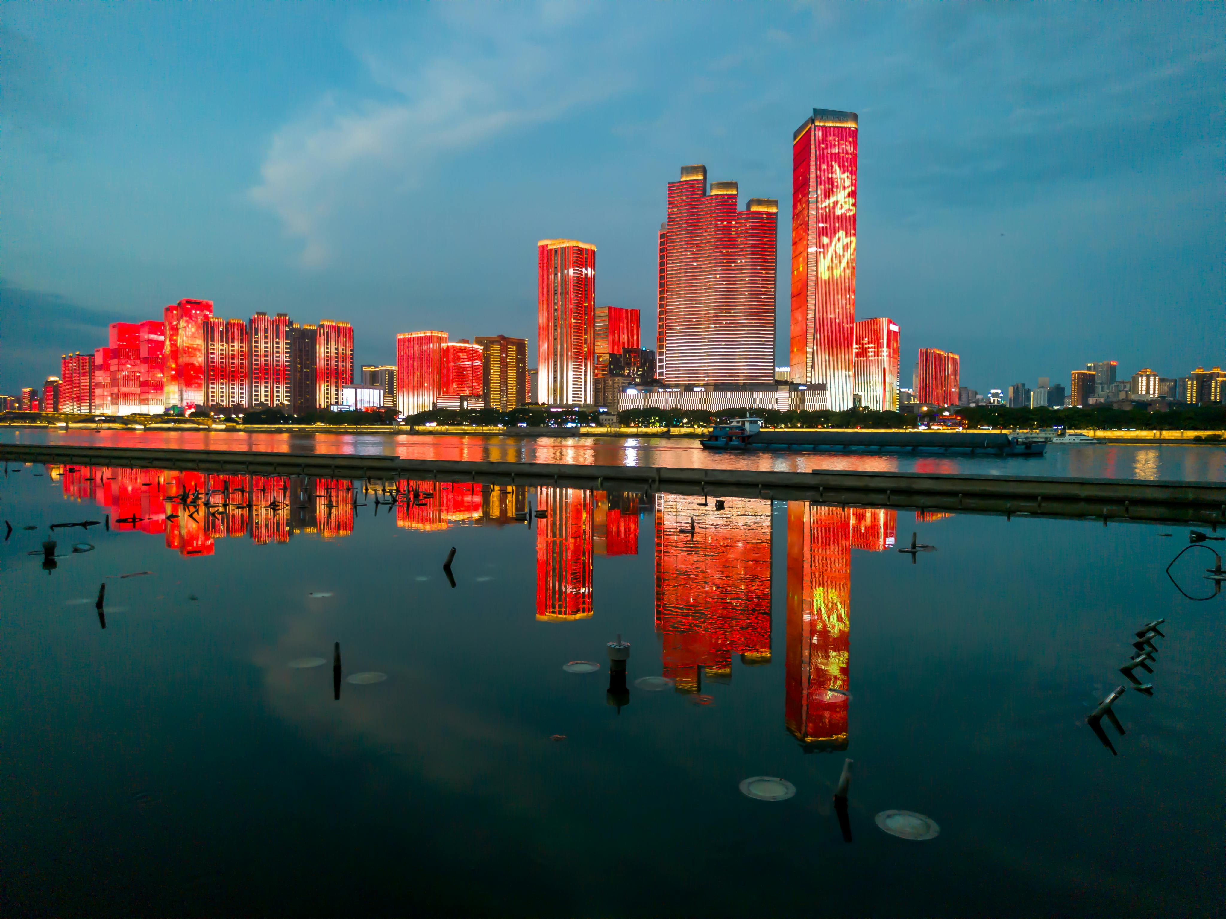 Stunning night view of Changsha's illuminated skyline reflecting in water.