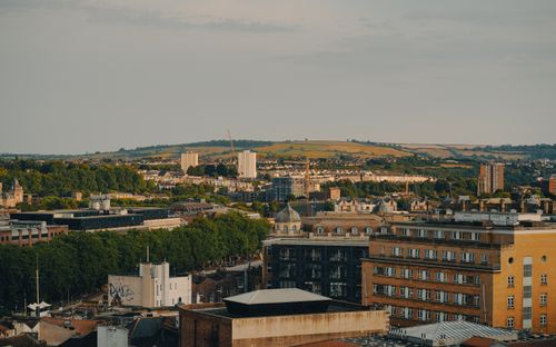 Free Panoramic view of city architecture against rolling hills under a clear sky. Stock Photo