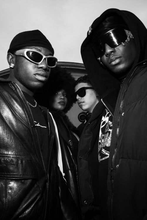 Free Trendy group of four adults posing in urban attire, highlighting afro-centric fashion. Stock Photo