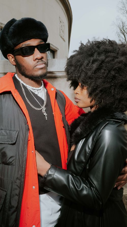 Free A fashionable couple embraces outdoors in stylish jackets and accessories, showcasing modern urban fashion. Stock Photo