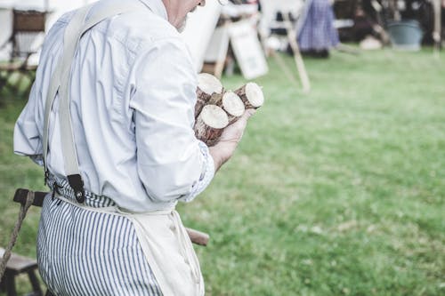 Man in White Dress Shirt Carrying Brown Wood Logs