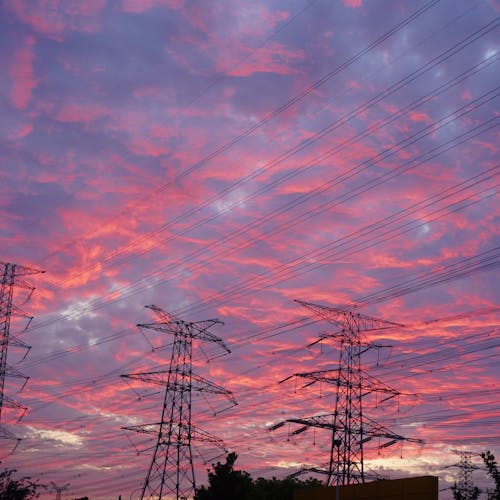 View of Electricity Towers and Lines under Pink Sunset Sky 